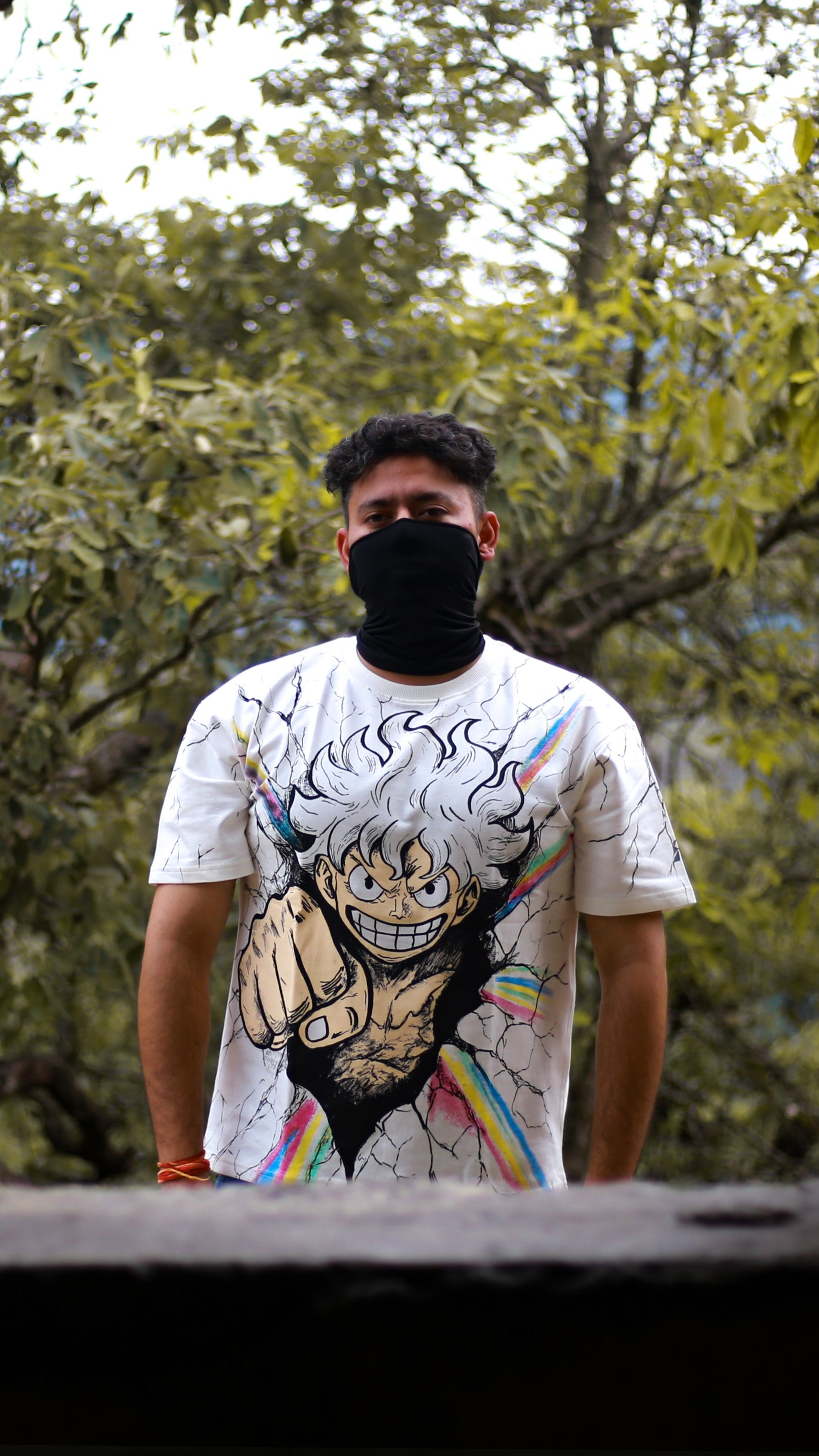 Person wearing a one piece anime  t-shirt with a graphic design in a natural setting